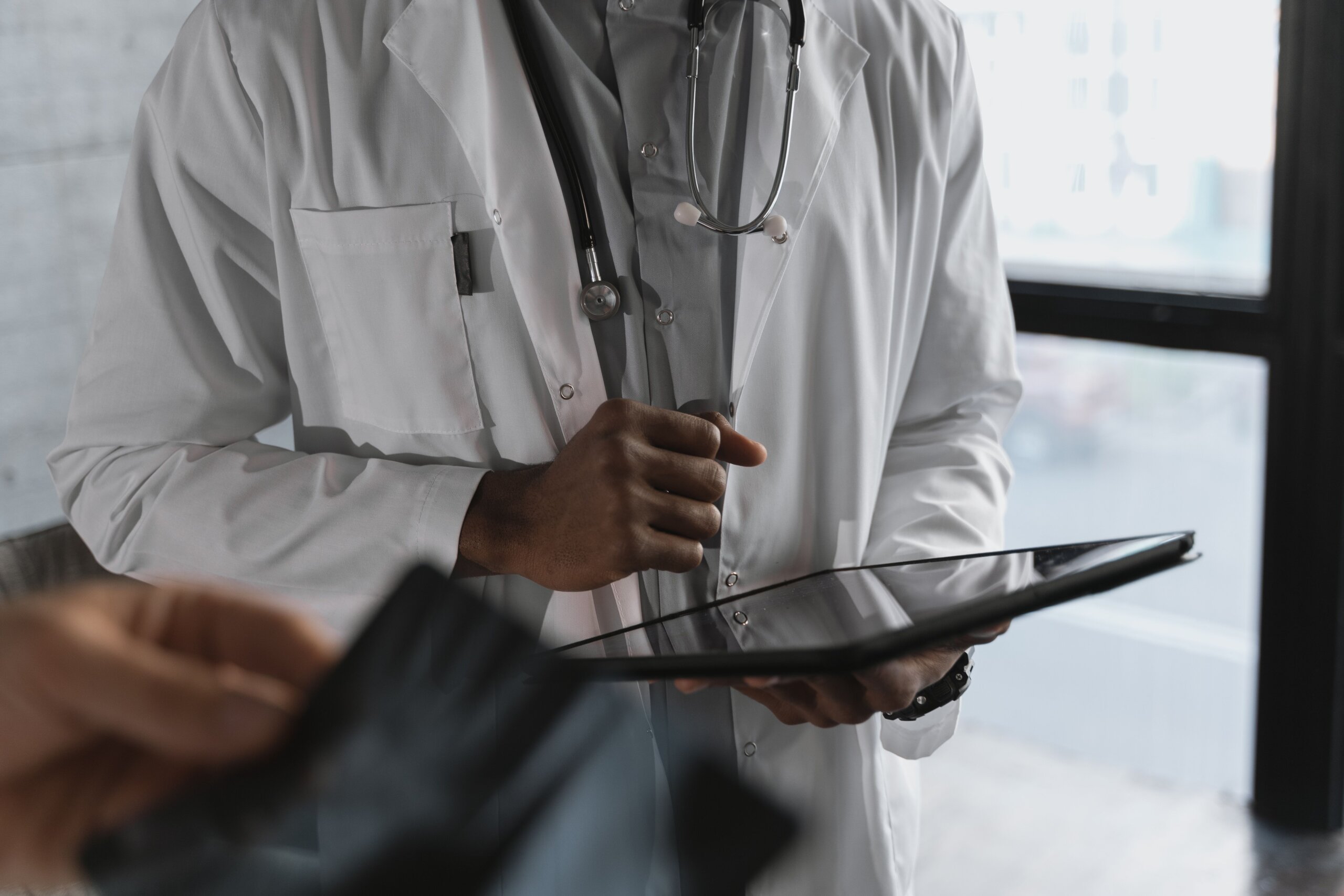 The image shows a doctor with a tablet